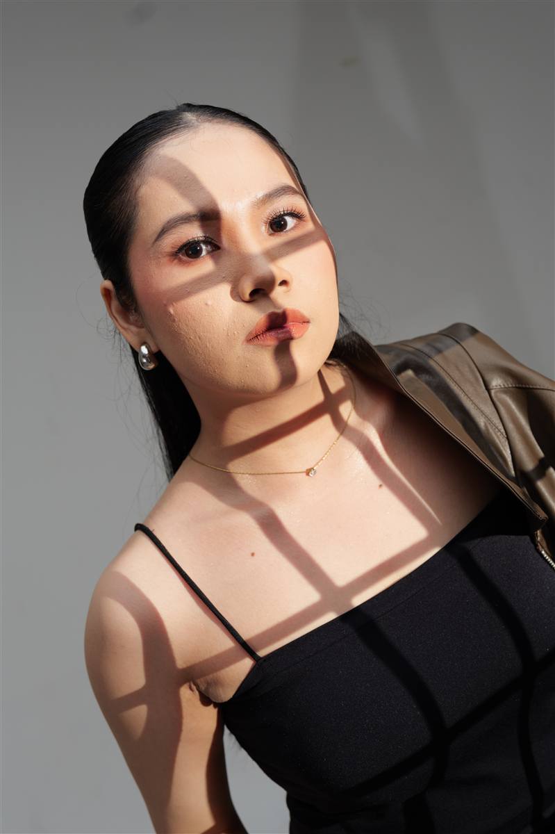 Woman with a shadow pattern across her face and shoulder